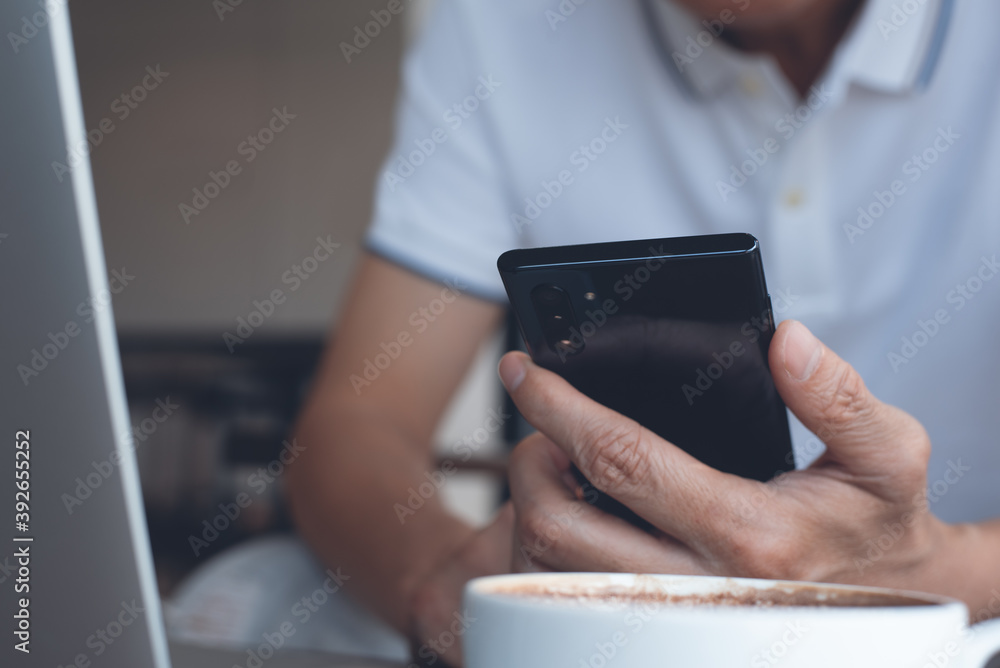 Aufkleber man using mobile phone during online working on laptop computer in coffee shop