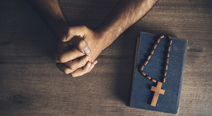 prayer man and wooden cross on the Bible