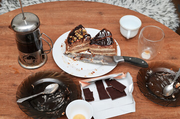 Photo of a sliced cake on a table with tableware after the holiday