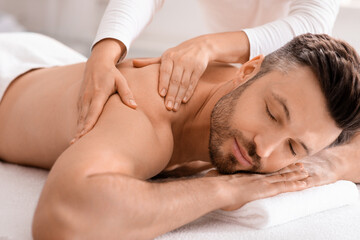 Fototapeta na wymiar Closeup of handsome man having full body massage at spa