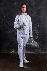 Teenage girl fencer dressed in uniform with epee and helmet