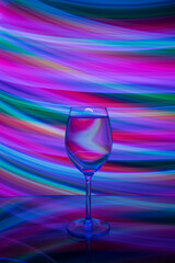Light painting was done behind a glass filled with liquid and reflection of the glass on a reflective surface