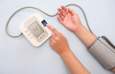Measurement of pressure. A woman monitors her health by checking the pressure and pulse on her arm....