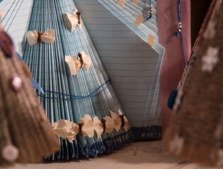 Close up of illuminated Christmas tree made of blue book pages with white bows on it.