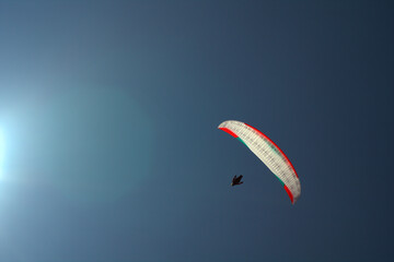 paraglider in the sky,sky, parachute, paragliding, sport, fly, paraglider, extreme,blue, air, adventure, flying, gliding, glider, freedom, wind, flight, fun, paraglide,