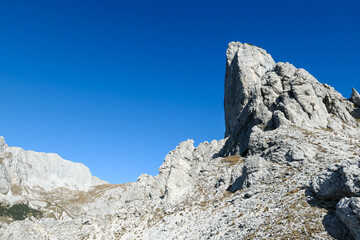 A view on a massive mountain wall in Alps in Hochschwab region, Austria. The slopes are really steep and dangerous to climb. Rocky landscape. Remote place, with no people. Freedom and wilderness