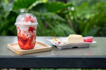 Milk strawberry smoothie and cheesecake in park cafe