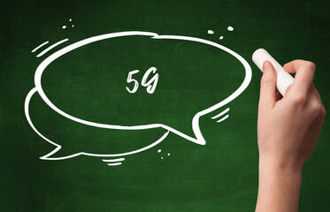 Hand drawing 5G abbreviation with white chalk on blackboard