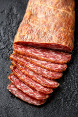 Dry cured pork meat salami slices in natural skin casing