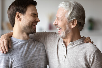 Close up overjoyed mature father with son laughing, excited older grandfather and grown up...