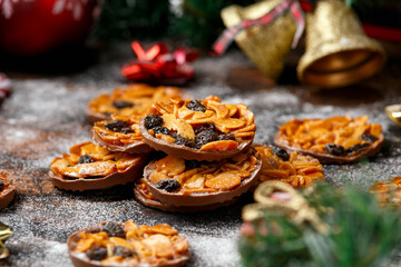 Christmas Chocolate Florentines cookies with almond and raisins with decoration, gifts, green tree branch on wooden rustic table
