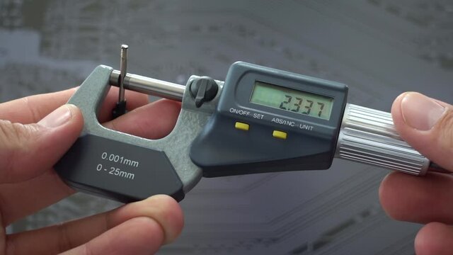 Engineer working with precise micrometer with digital display for quality control. Close up horizontal video of accurate measuring instrument. Micrometer tool showing the exact diameter and thickness.