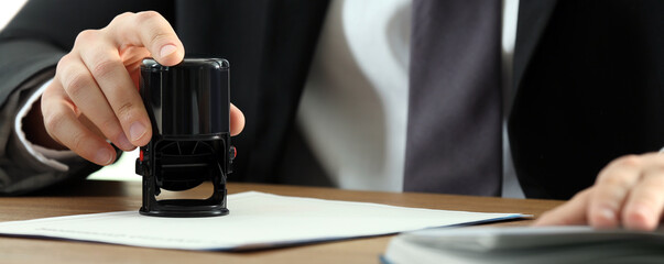 Notary stamping document at table, closeup. Banner design