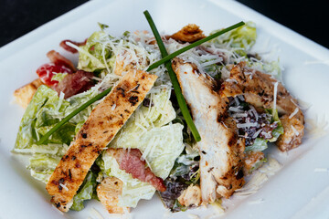 Grilled chicken salad on a white plate