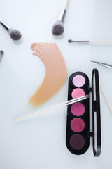 makeup shadow palette with brushes and a smear of Foundation