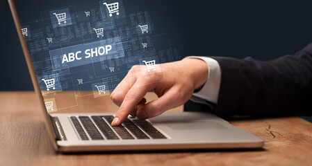 Fototapeta na wymiar Businessman working on laptop with ABC SHOP inscription, online shopping concept