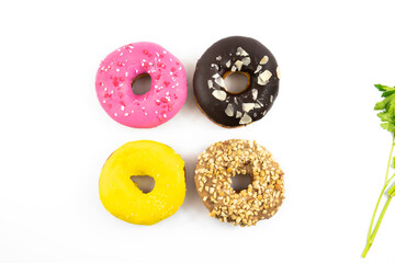 Fototapeta premium Four assorted donuts chocolate strawberry and others top view on white isolated background