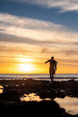 Silhouette of a surfer at sunset
