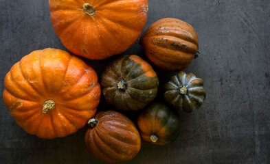 Fresh golden nuggets and acorn squashes on grey textured background with copy space. Top view photo...