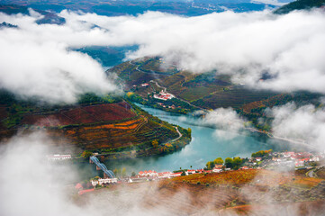 Pinhao village in Douro river valley in Portugal. Vineyards on the mountains in misty morning. Top view. Portuguese wine region. Beautiful autumn landscape.
