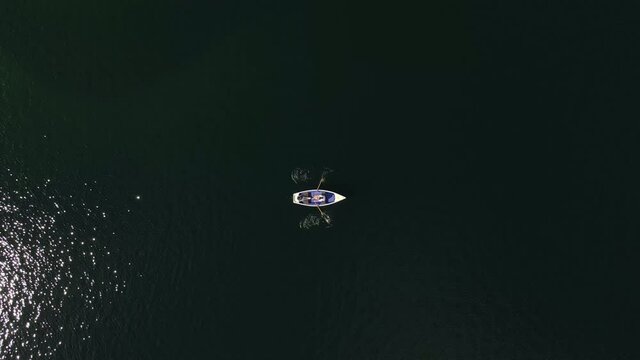 Birds Eye View of rowboat on a lake, couple, shipping, landscape, nature, love, relax, dinghy, static, lovers, aerial drone shot, Slow Motion