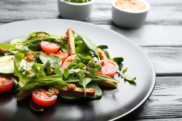 Delicious fresh chicken salad served on black wooden table, closeup