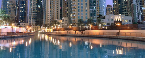Sich im  Wasser spiegelnde Hochhäuser Dubais bei abendlicher Beleuchtung