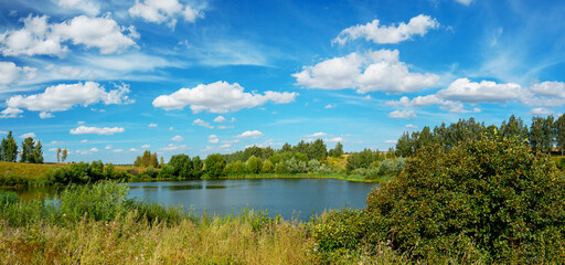 Bright summer landscape with beautiful lake and green hills