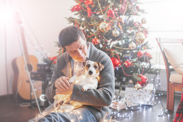 Man with dog near christmas tree
