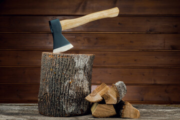 Axe and firewood, against the background of wooden boards.