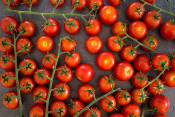 A lot of cherry tomatoes on a table. Grey background. Top view photo of fresh vegetables. 
