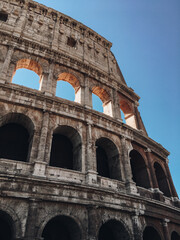 Fototapeta premium Colosseum in Rome against the blue sky. Traveling to Italy, Rome. City Landmark.