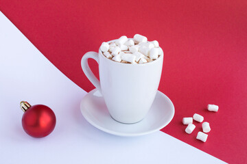 Hot chocolate or cocoa with marshmallows in the white cup on the bicolor background. Copy space.