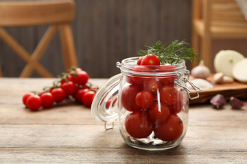Pickling jar with fresh tomatoes on wooden kitchen table