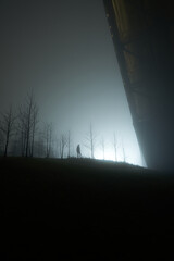 A man stands and beholds the ski jump, Holmenkollen in Norway. The biggest jump in Norway. The fog is dense and the silhouette creates magic
