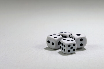  White playing dice cubes in motion on the white canvass surface