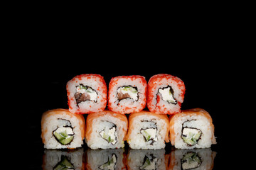Philadelphia roll with salmon, cheese and cucumber on a black background with reflection. Sushi Philadelphia