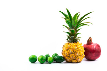 Baby pineapple exotic fruit with feijoa and pomegranate composition with negative space on white isolated background