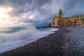 Scenic view of Camogli seaside with cloudy dramatic sky sea waves and buildings