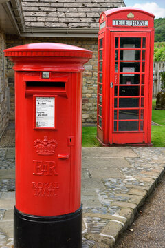 Communication by Red Royal Mail mailbox and red English Telephone booth at Bolton Abbey Wharfedale, North Yorkshire, England - June 19, 2019