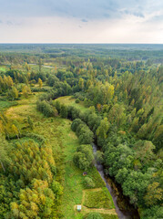 Fototapeta premium Aerial view of river among the forest. Summer nature landscape. Sunset.