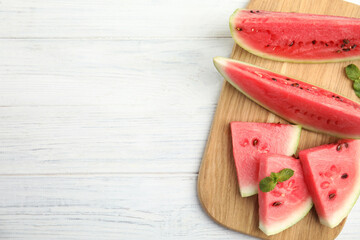 Tasty ripe cut watermelon on white wooden table, top view. Space for text
