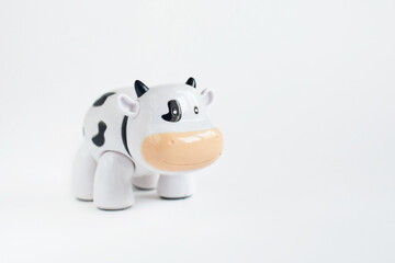 The toy is a white cow with black spots. Symbol of 2021