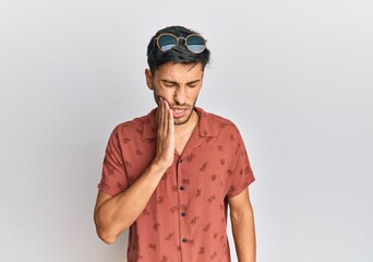 Young handsome man wearing casual summer clothes touching mouth with hand with painful expression because of toothache or dental illness on teeth. dentist