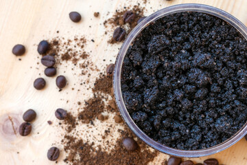 Bowl full of ground coffee scrub with olive oil and salt as homemade facial and body scrub. Homemade cosmetics for peeling and rejuvenation, anti-cellulite spa product, top view