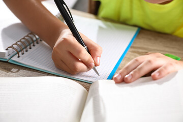 Preteen girl doing homework at table, closeup