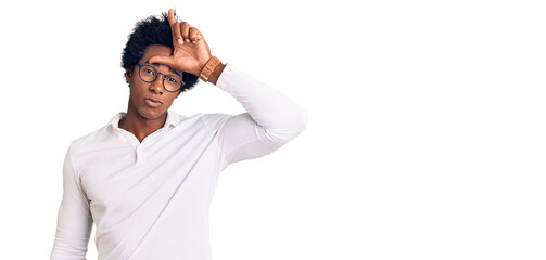 Handsome african american man with afro hair wearing casual clothes and glasses making fun of...