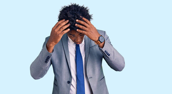 Handsome african american man with afro hair wearing business jacket suffering from headache desperate and stressed because pain and migraine. hands on head.