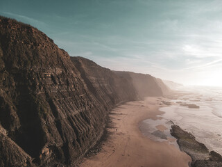 Aerial view of waves on a beautiful sandy ocean beach and cliff. Panorama atlantic coastline.