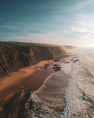 Fototapeta na wymiar Aerial view of waves on a beautiful sandy ocean beach and cliff. Panorama atlantic coastline.